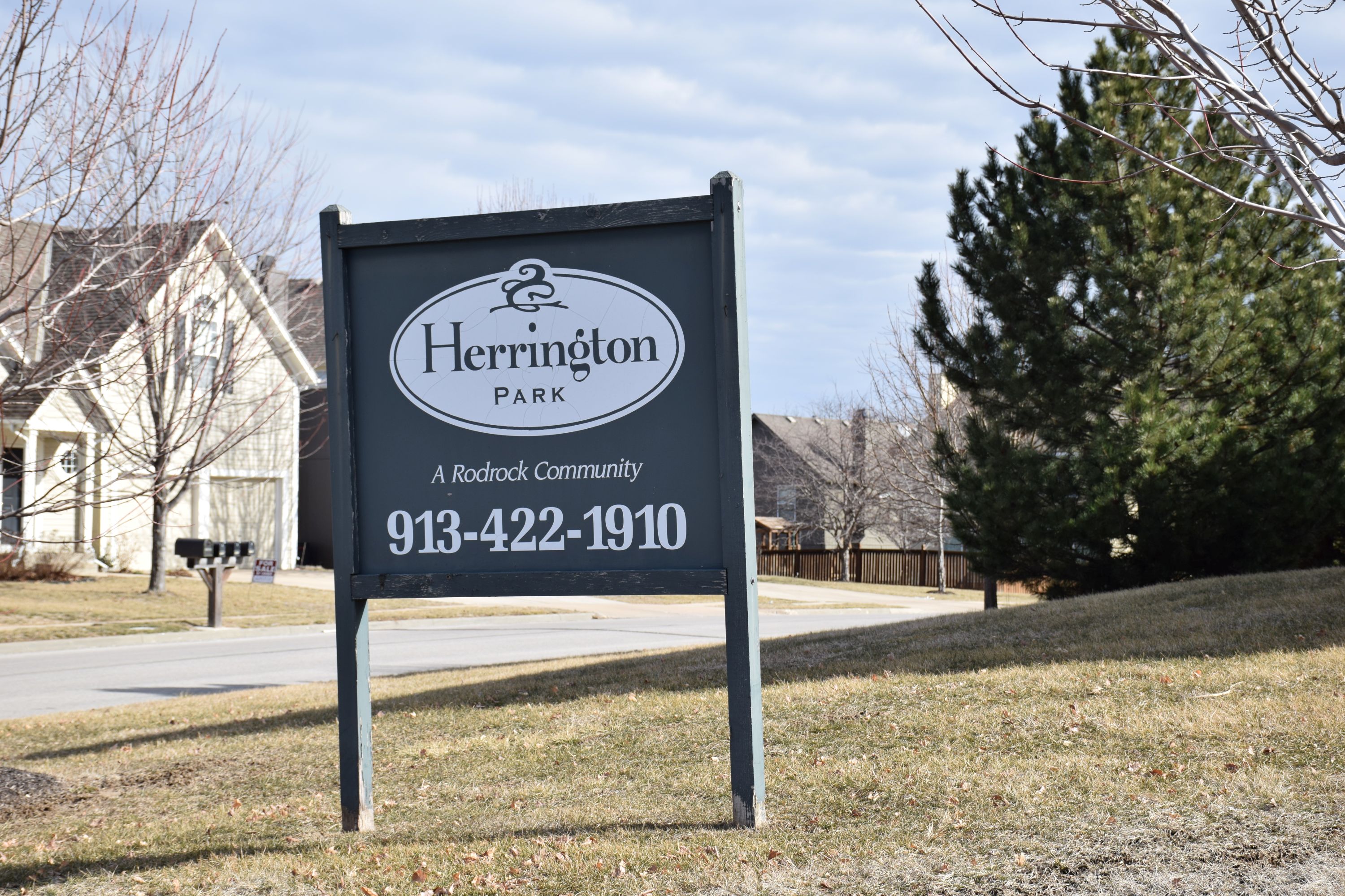 A sign for Herrington Park, a Rodrock community, is displayed in front of a house.